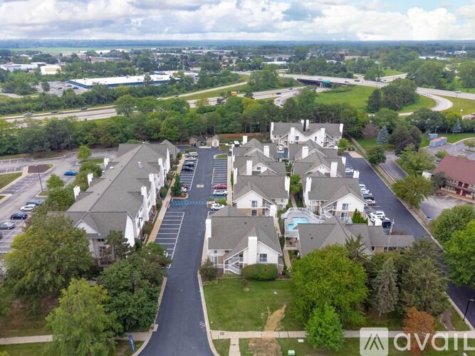 A bird's eye view of a residential area with houses and a parking lot.