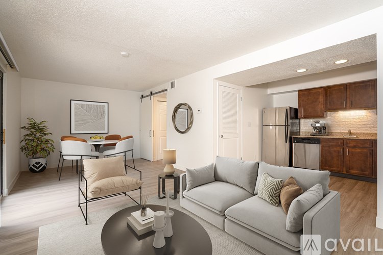 A modern living room with a grey sofa and a glass coffee table.