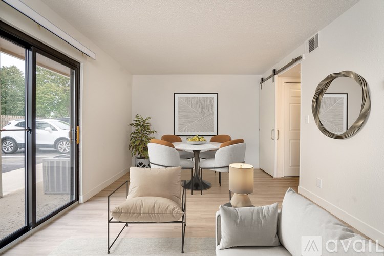 A modern dining room with a glass table and chairs.