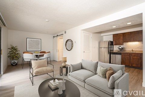 A modern living room with a grey sofa and a glass coffee table.