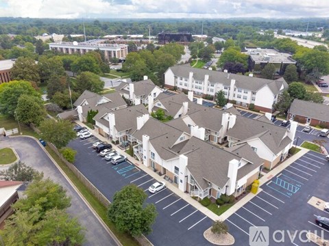A large white building with a parking lot in front.