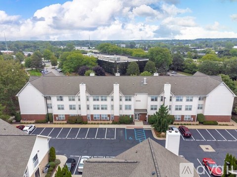 A large white building with a parking lot in front.