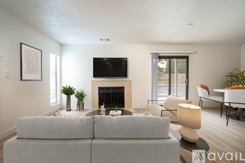 A living room with a grey couch, a fireplace, and a television.