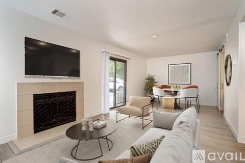 A living room with a fireplace and a television mounted on the wall.