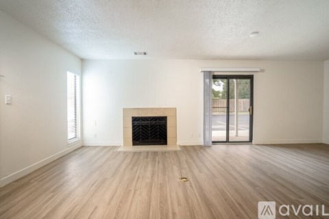 A spacious living room with a fireplace and sliding glass doors.