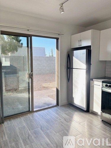 A kitchen with a refrigerator, oven, and cabinets.