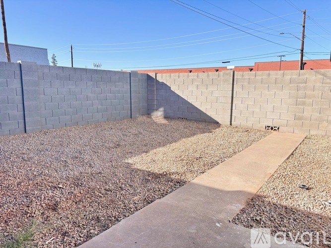 A concrete wall with a gravel area in front of it.