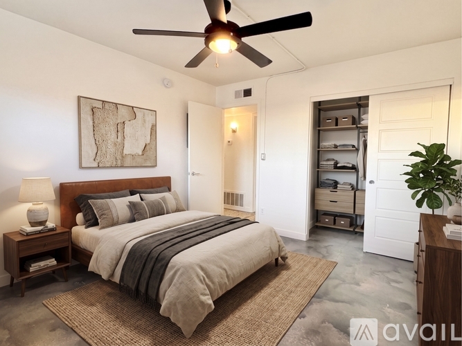 A bedroom with a large bed and a ceiling fan.