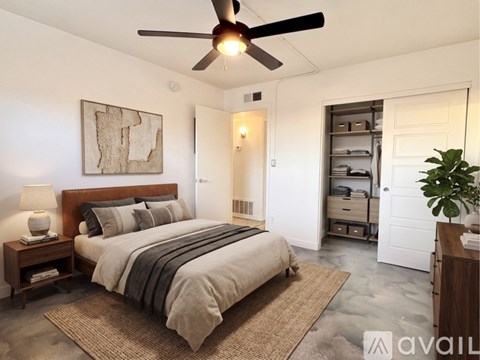 A bedroom with a large bed and a ceiling fan.