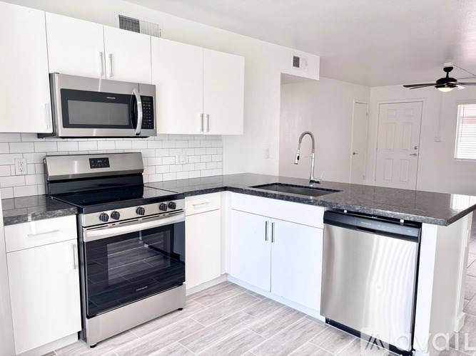 A modern kitchen with white cabinets and stainless steel appliances.