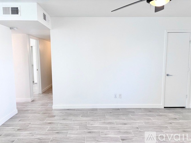 A room with a ceiling fan and a door.