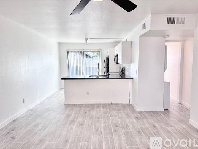 A spacious kitchen with white cabinets and a black countertop.