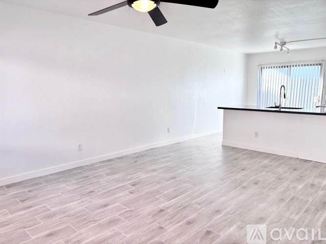 A room with a ceiling fan and a window with blinds.