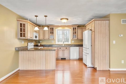 A kitchen with wooden cabinets and a granite countertop.