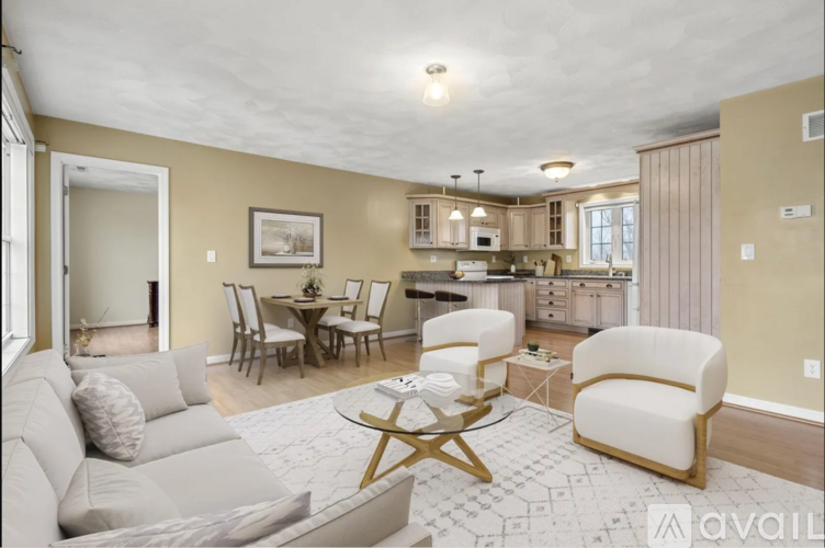 A living room with a couch, chairs, and a coffee table.