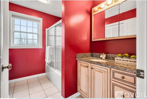 A bathroom with red walls and a white door.