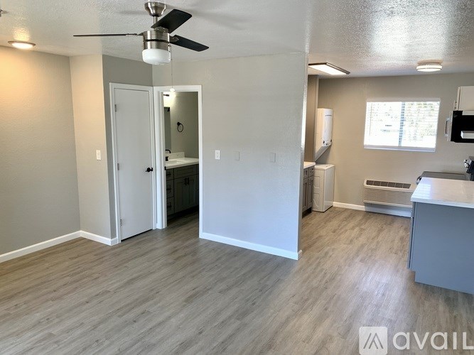 A room with a ceiling fan and a door leading to another room.