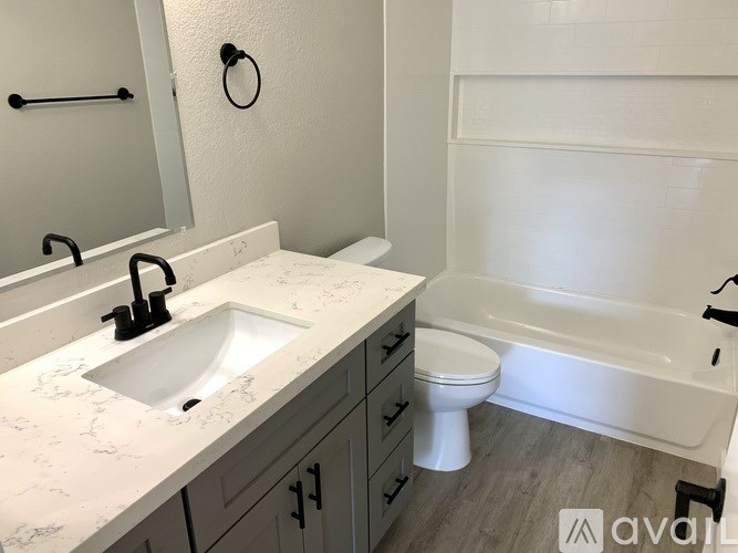 A bathroom with a marble countertop and white fixtures.