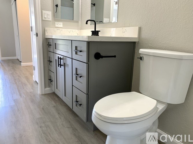 A white toilet sits next to a sink with a black faucet.