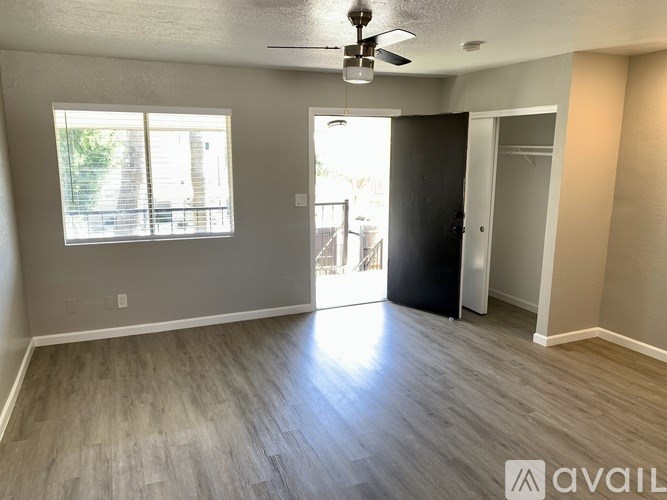 A room with a ceiling fan and a window with blinds.