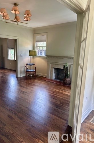 A living room with a fireplace and a lamp on a side table.