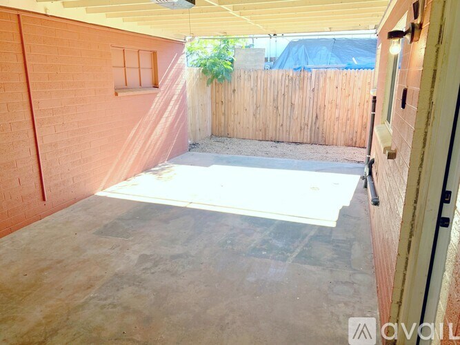 A patio area with a wooden fence and a white table.
