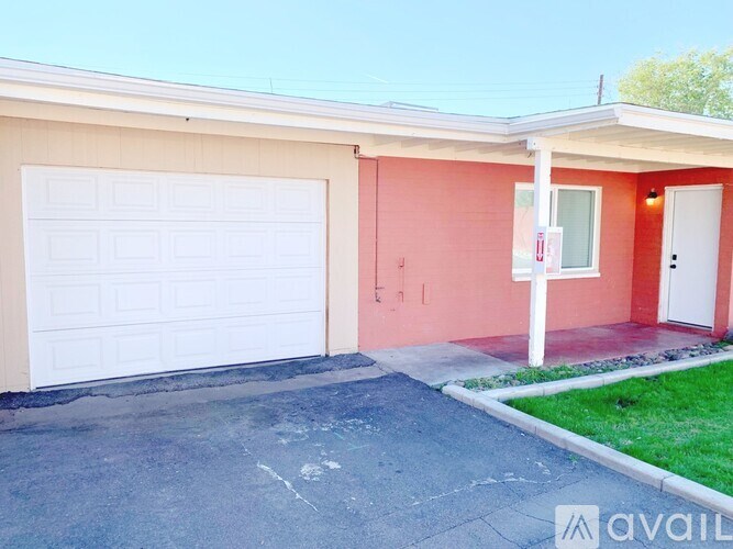 A garage door of a house with a red wall.