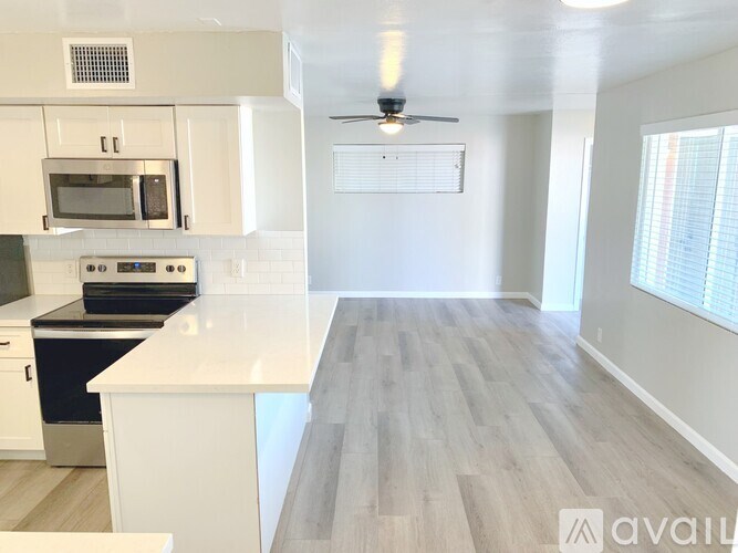 A kitchen with white cabinets and a white countertop.