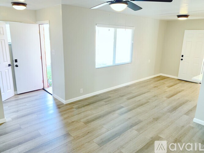 A room with a wooden floor and a ceiling fan.