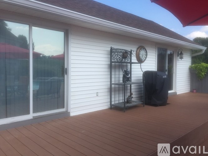 A white house with a red umbrella and a black mailbox.