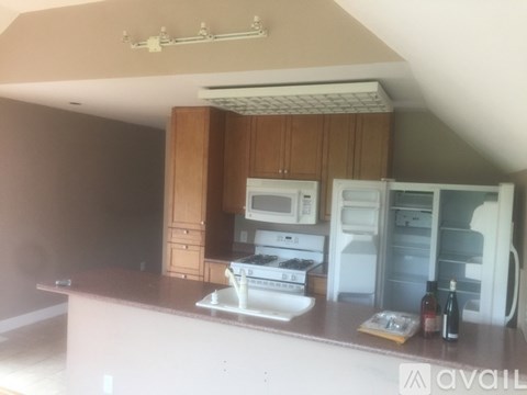 A kitchen with a white counter top and a white fridge.