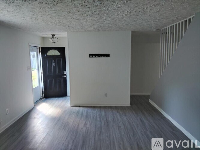 A room with a door and a window, the room is empty and waiting to be furnished.