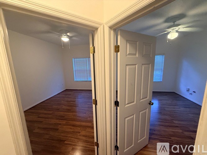 A room with wooden floors and a ceiling fan.