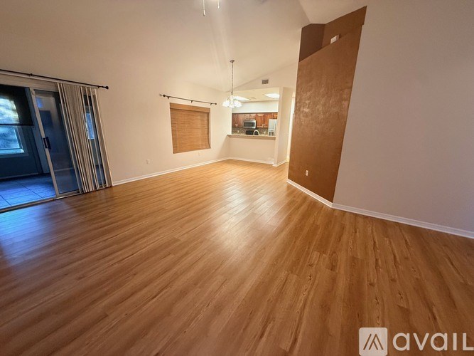 A room with wooden flooring and a sliding glass door.
