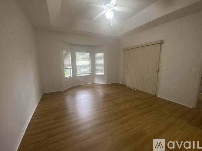 A room with wooden flooring and a ceiling fan.