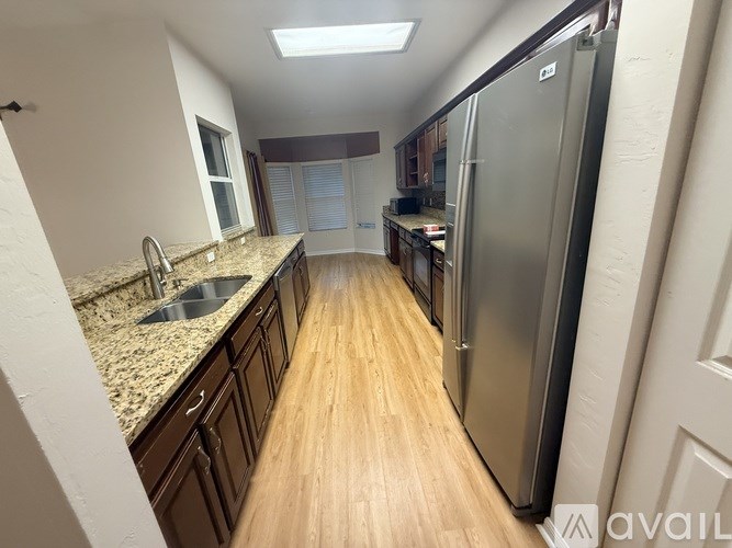 A spacious room with tiled flooring and a large window with blinds.