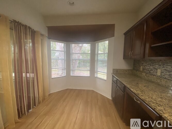 A kitchen with wooden floors and a stone countertop is available.