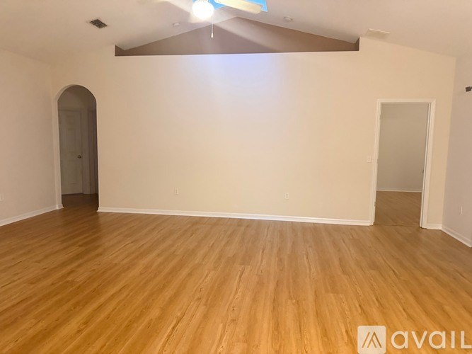 A room with wooden flooring and a chandelier.
