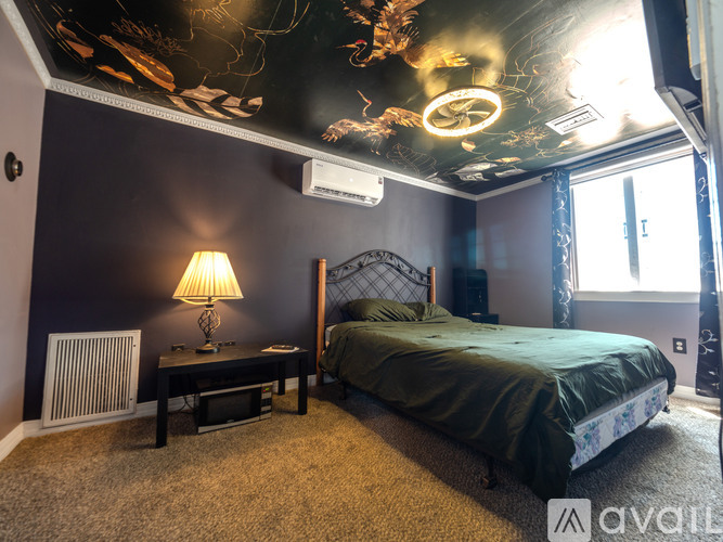 A bedroom with a bed, nightstand, and lamp.