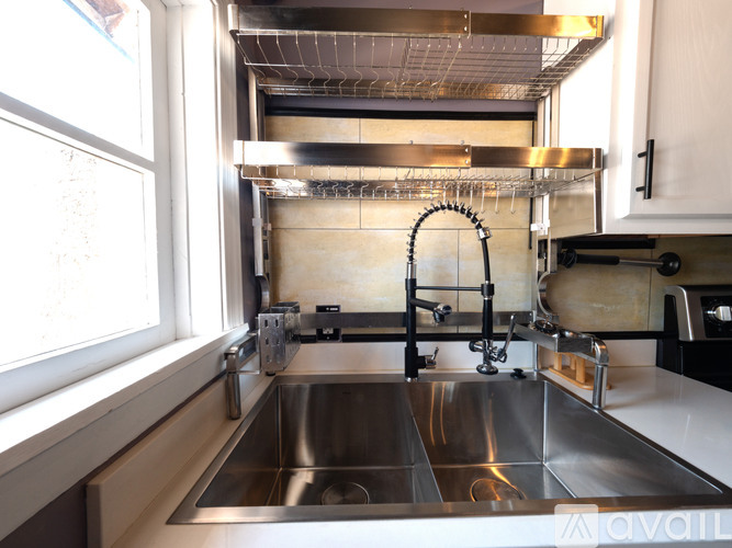 A modern kitchen with a stainless steel sink and faucet.