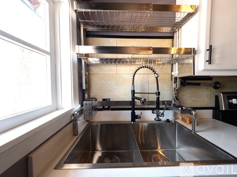 A modern kitchen with a stainless steel sink and faucet.