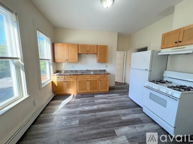 A kitchen with a white stove and wooden cabinets.