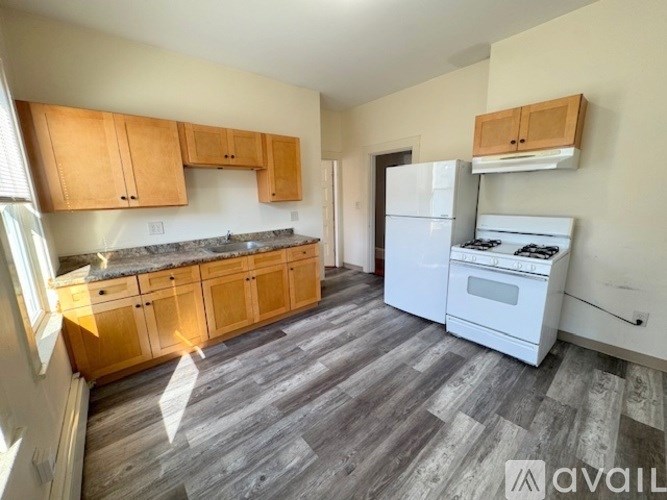 A kitchen with wooden cabinets and a white fridge.