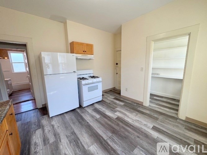 A kitchen with a white fridge and stove top oven.