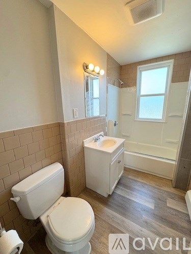A bathroom with a toilet, sink, and bathtub.
