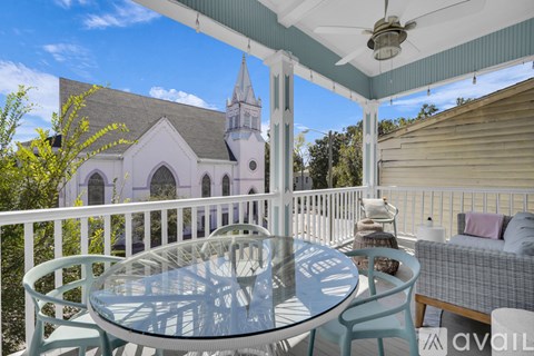 A patio with a table and chairs overlooking a church.