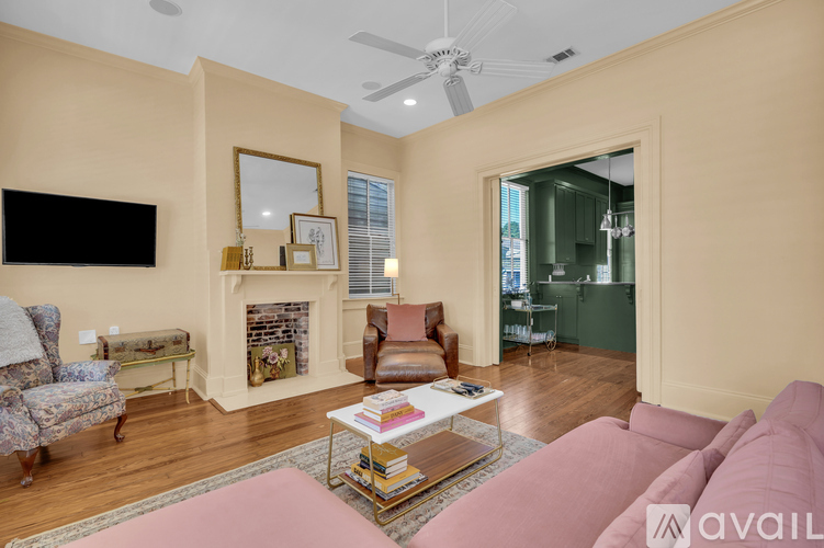 A living room with a pink couch and a fireplace.
