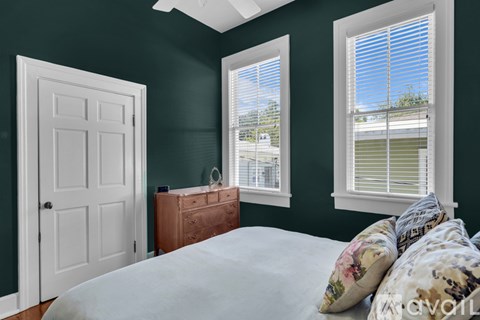 A bedroom with a bed, dresser, and window.