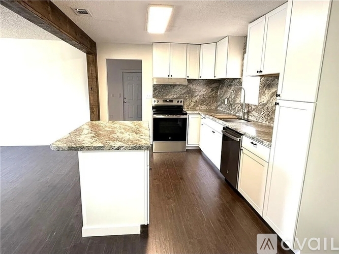 A kitchen with a granite countertop and white cabinets.