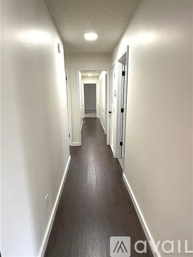 A long hallway with doors on both sides and a light on the ceiling.